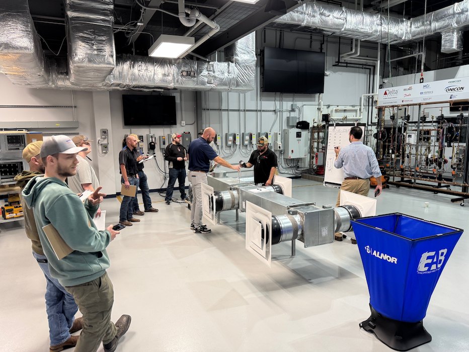 Hands-on TAB advanced air and water systems training showing real-world airflow measurement and system balancing instruction